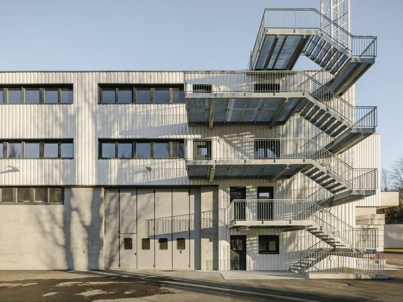 modern architectural design, steel cladding, large windows, emergency staircase, raised ground floor, large entrance doors