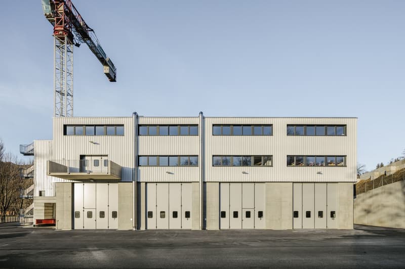 modern design, steel structure, many windows, balcony on the left side, large garage doors