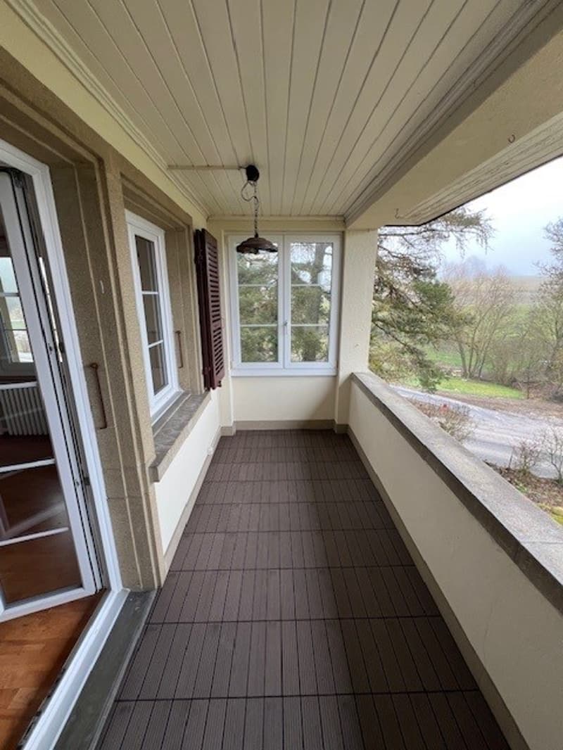Decked balcony with ceiling lamp, floor windows and railing