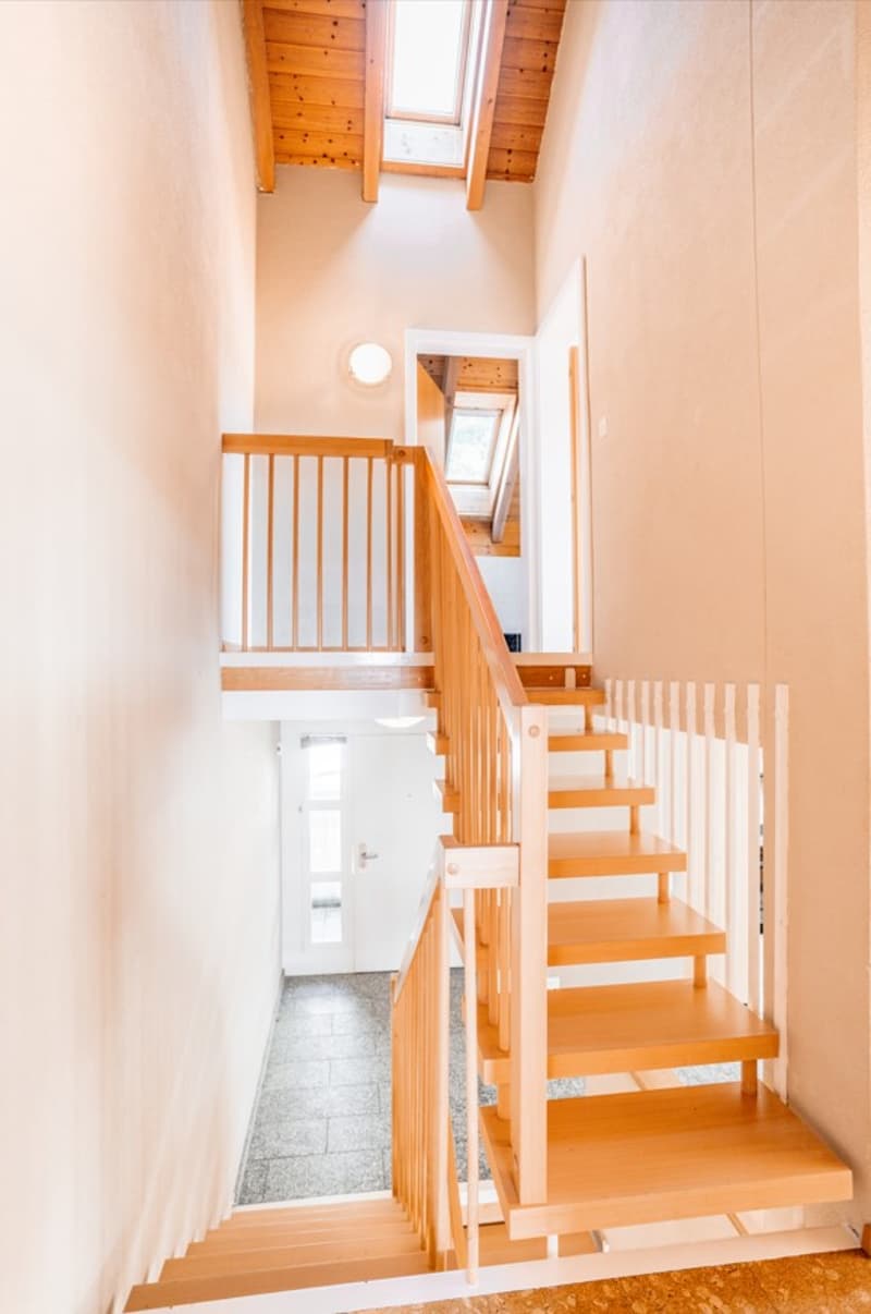 wooden staircase, white walls, wooden handrail, white door, skylight