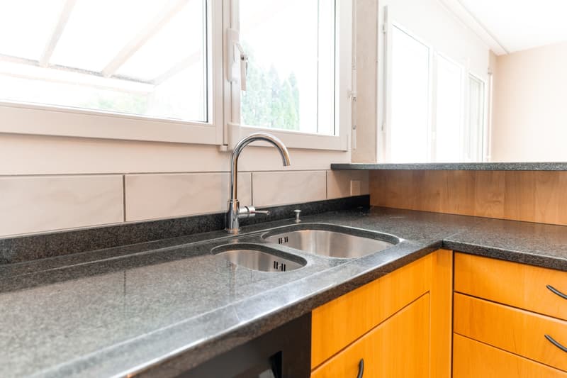 modern kitchen with granite countertops, stainless steel sink, wooden cabinets, double sink, faucet, windows
