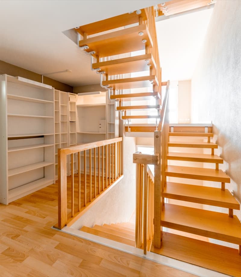 wooden staircase, wooden handrail, wooden steps, white walls, white shelves