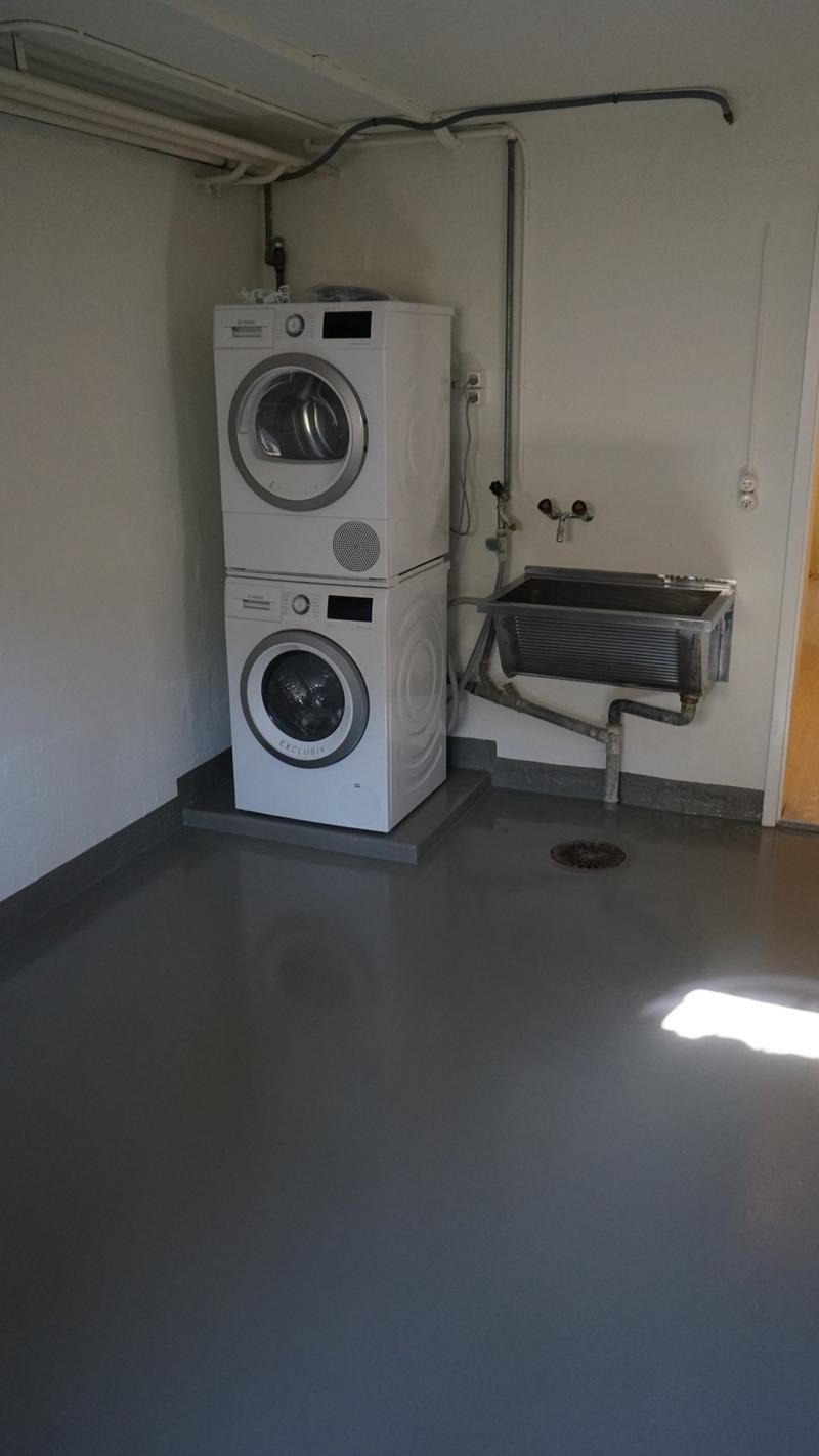 room with washing machine, washing dryer and a sink.