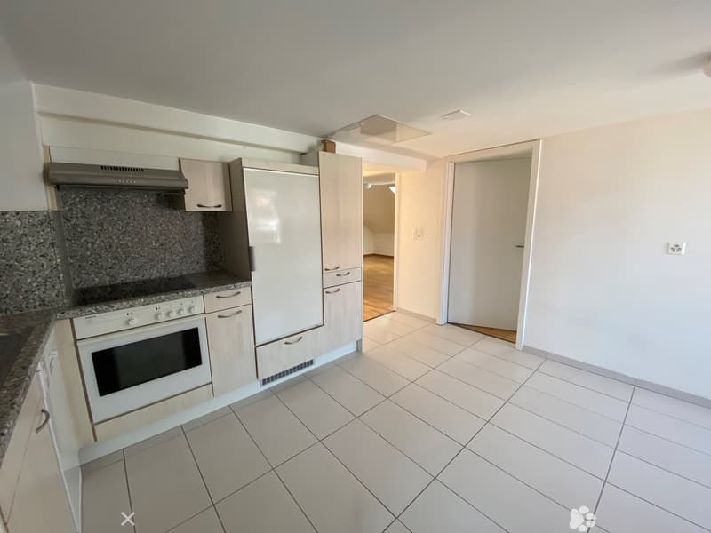 modern kitchen with white tiles, white cabinets, white appliances, granite countertop, and a wooden floor