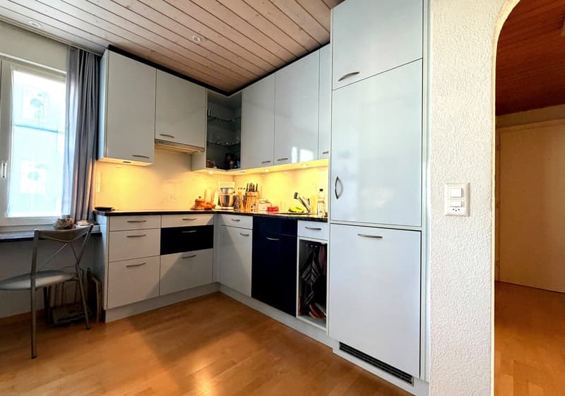 modern kitchen with white cabinets, wooden floor, sink, dishwasher, washing machine, window, power outlet