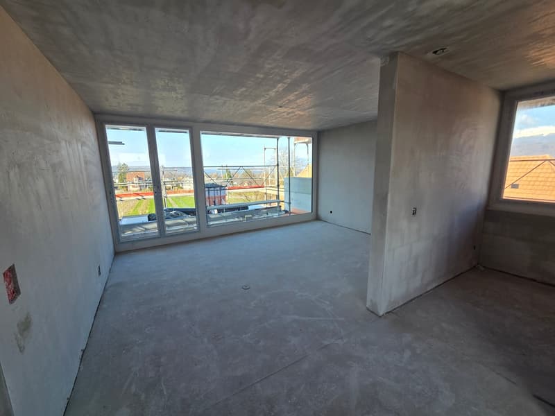 empty room, concrete floor, large windows, unfinished walls