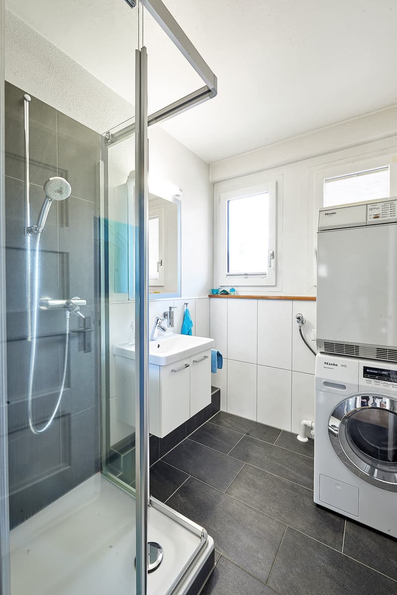modern bathroom with shower, sink, toilet and washing machine