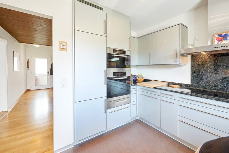modern design, white cabinets, granite countertop, stainless steel appliances, black stovetop, white ceiling