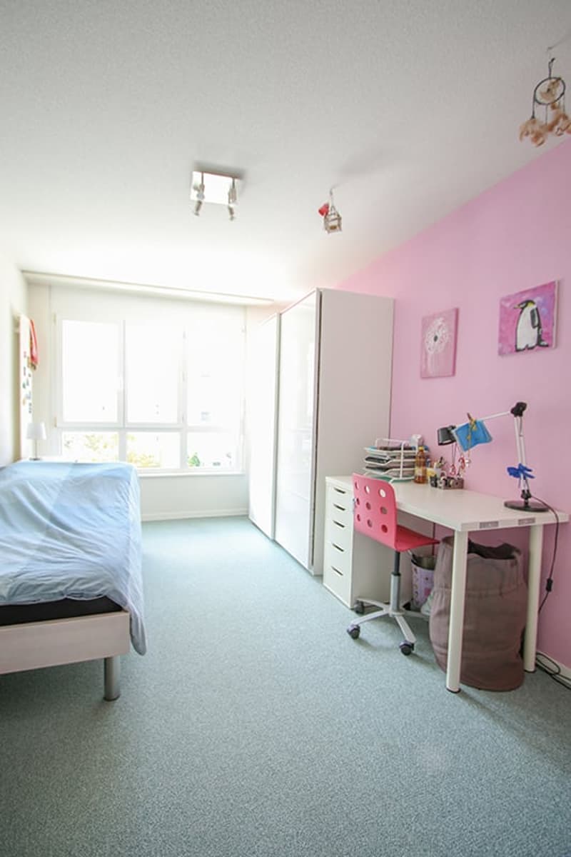 small room with bed, desk, chair, wardrobe, pink wall, white flooring