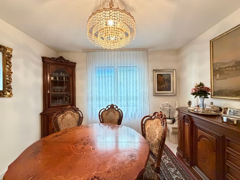 round table, 6 chairs, chandelier, window with curtains, sideboard, cabinet with glasses