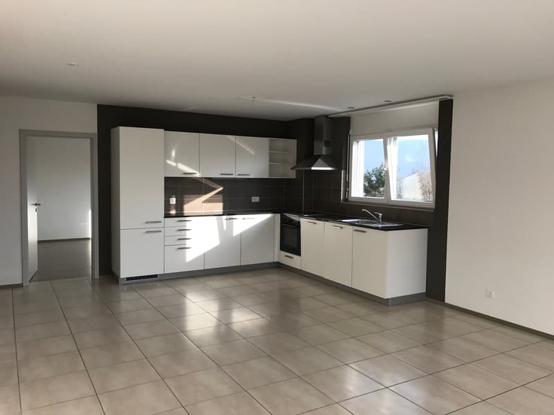 modern kitchen with white cabinets, tiled floor, black countertops, stainless steel sink, window with view