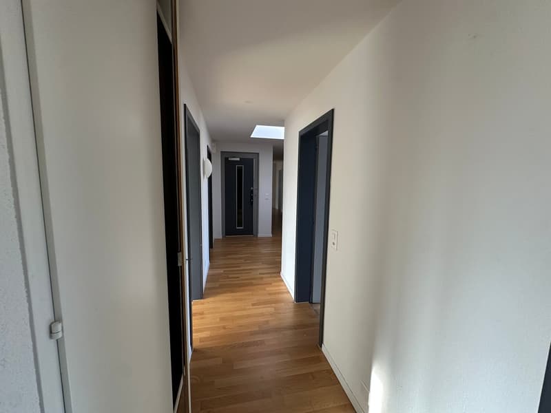 empty hallway, wooden floors, white walls, two doors