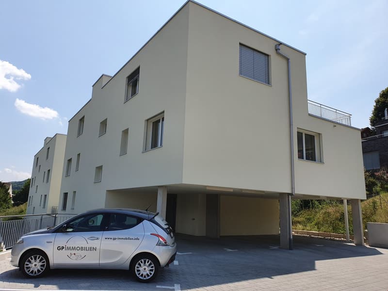 3 story building, white walls, beige columns, garage, raised ground floor