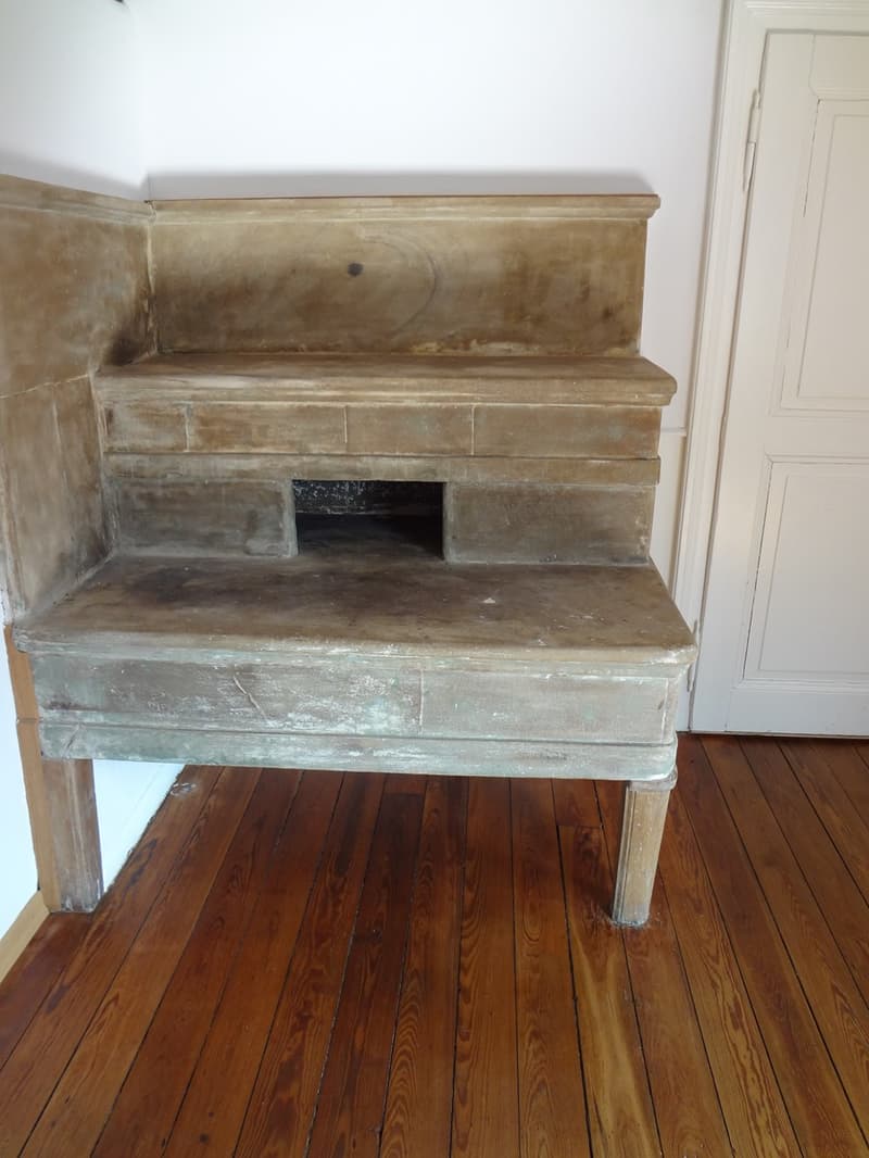 Large fireplace in a corner with wooden floor