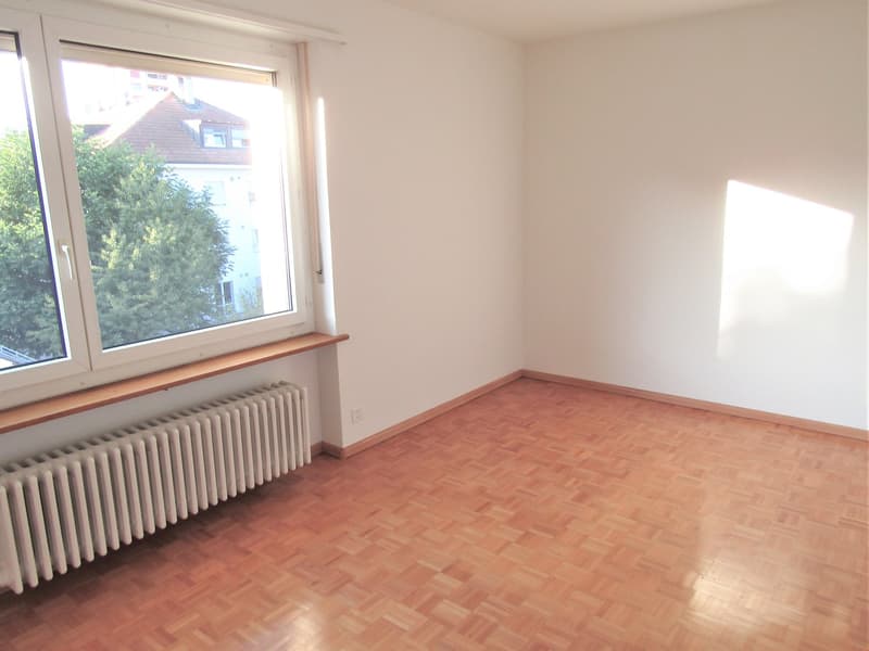 empty room, wooden floor, white walls, large window, radiator