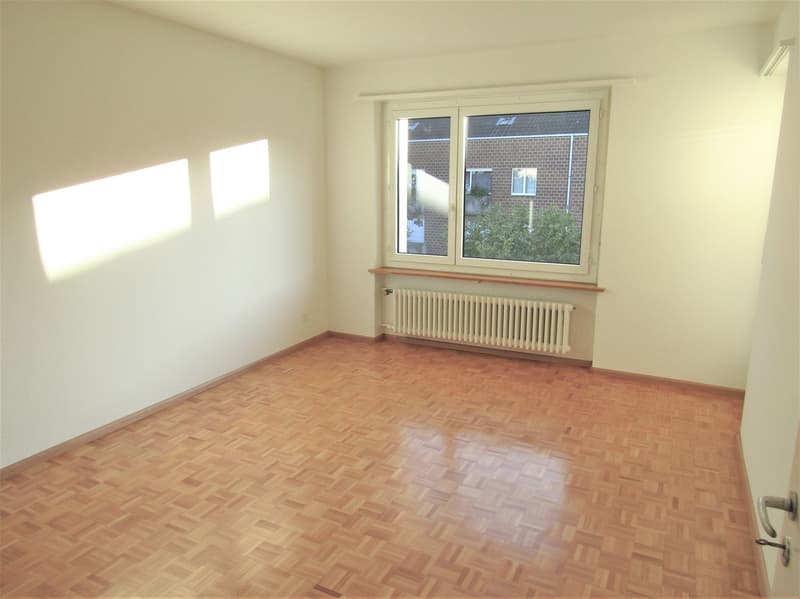 empty room, wooden floor, white walls, large window, white radiator