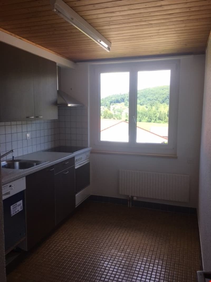 empty kitchen with sink, stove, cabinets, window, and washing machine