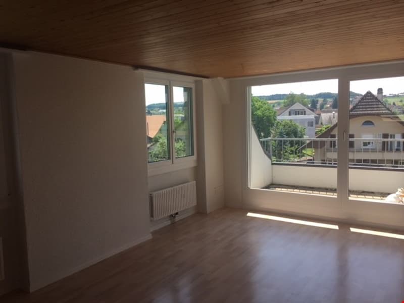 empty room, wooden floor, white walls, large windows, balcony with railings