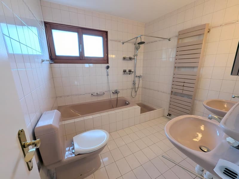 Bathroom with bathtub, shower, two sinks, and a toilet.