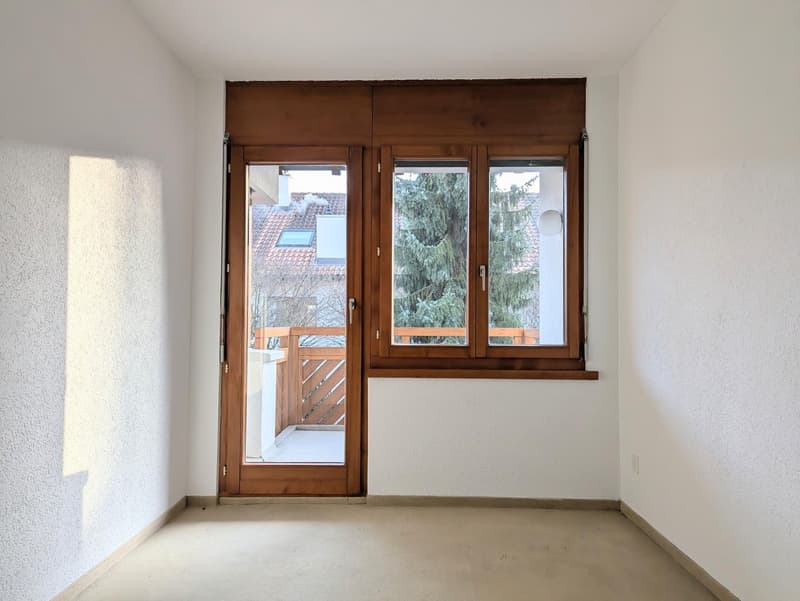 empty room, wooden door, glass door, balcony, white walls, white floor