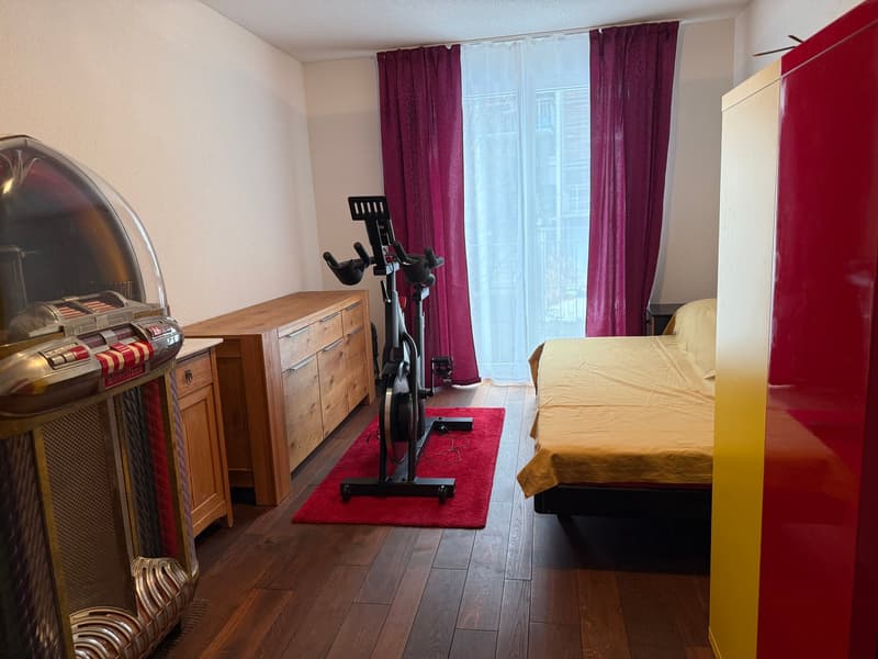 room with bed, exercise bike, and jukebox