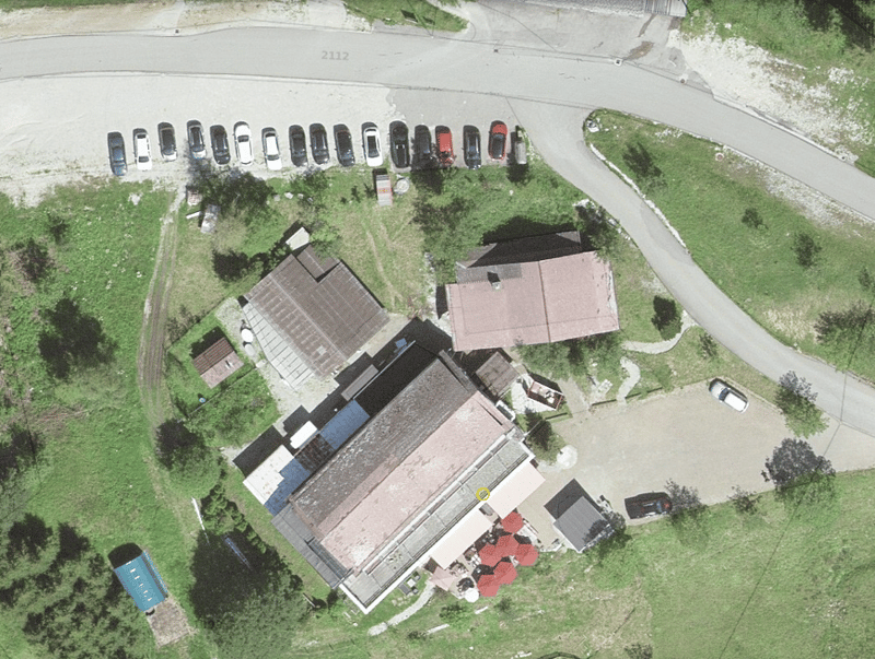 a collection of residential and commercial buildings with a parking area in the vicinity