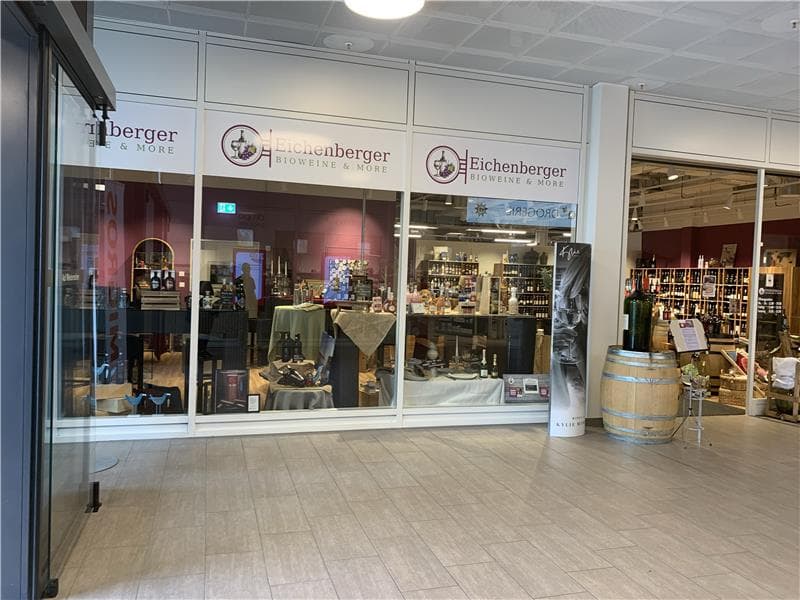 Wine shop front with large glass doors and shelves filled with wine bottles and items