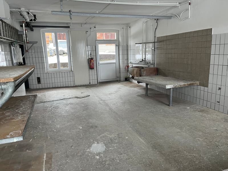 empty room, white tiled walls, two windows, door, fire extinguisher, metal tables, metal benches