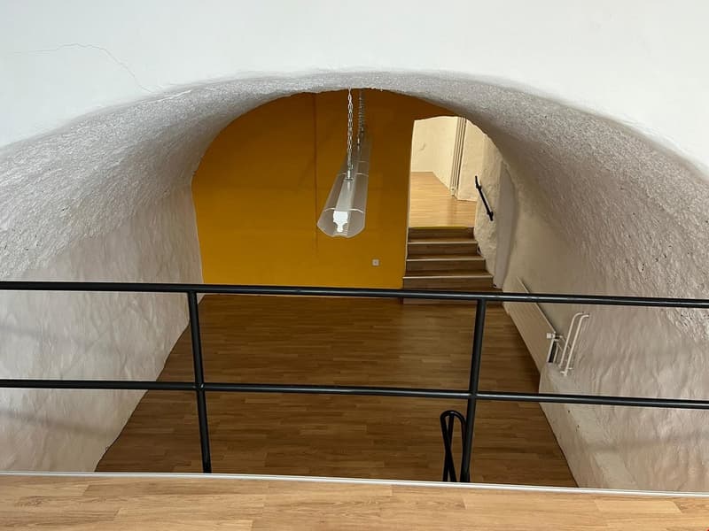 wooden floor, white ceiling, yellow wall, hanging light, metal railing