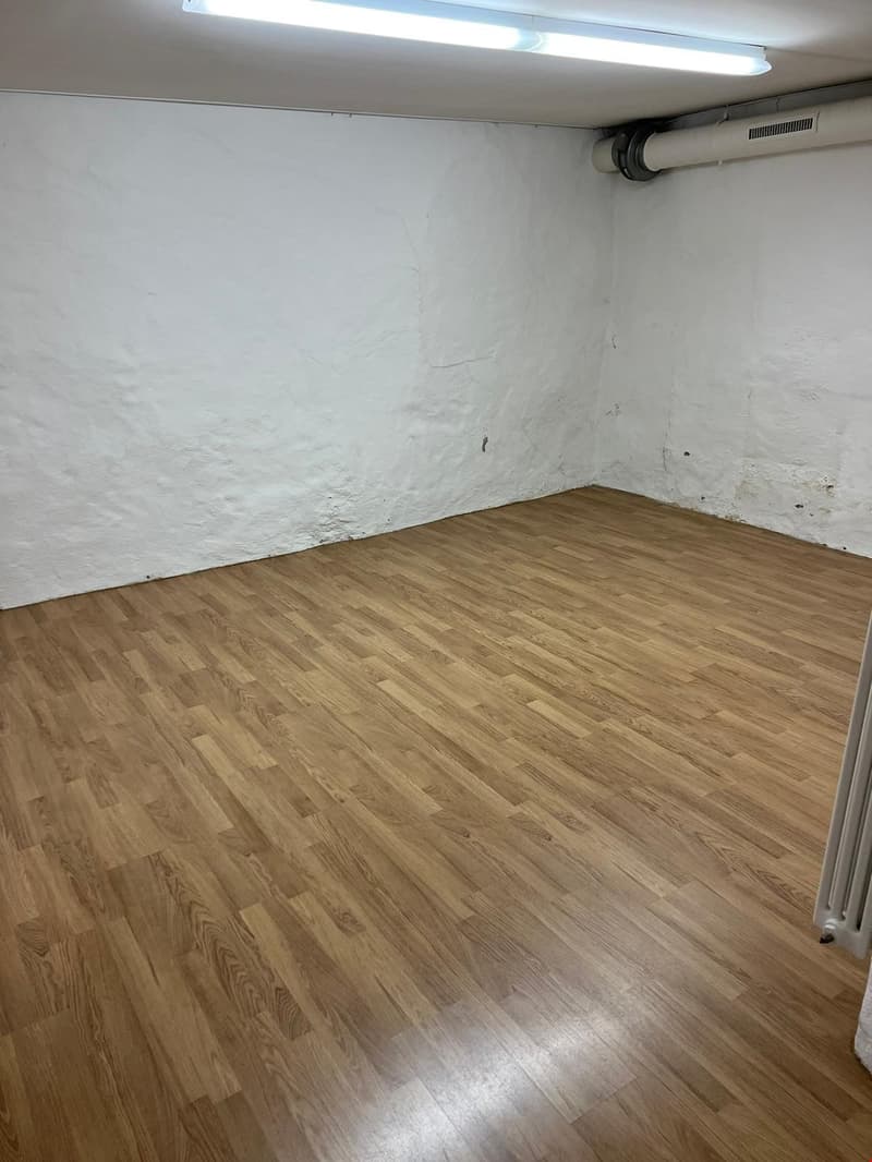 empty room, wooden floor, white walls, a radiator, a ceiling lamp