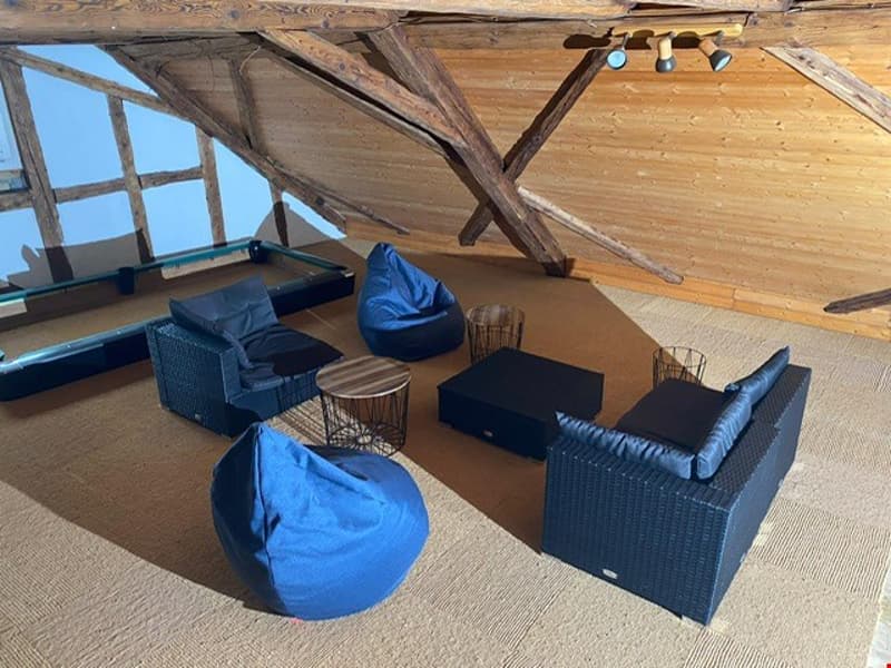 beamed wooden ceiling, blue bean bags, wooden coffee table, metal box sofa, billiards table