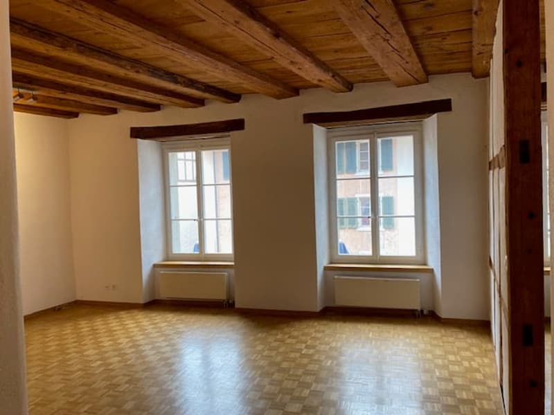 empty room, wooden ceiling, wooden floor, white walls, 2 windows, white radiators