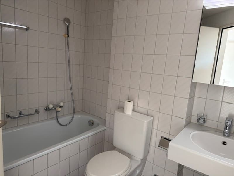 Bathroom with bathtub, toilet, sink, mirror, and shower head