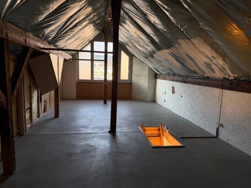 empty attic room, wooden beams, concrete floor, window, trapdoor