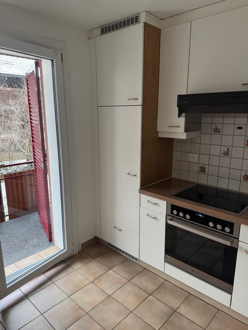 modern kitchen with white cabinets, tiled floor, balcony, gas stove, oven, extractor hood, power outlet