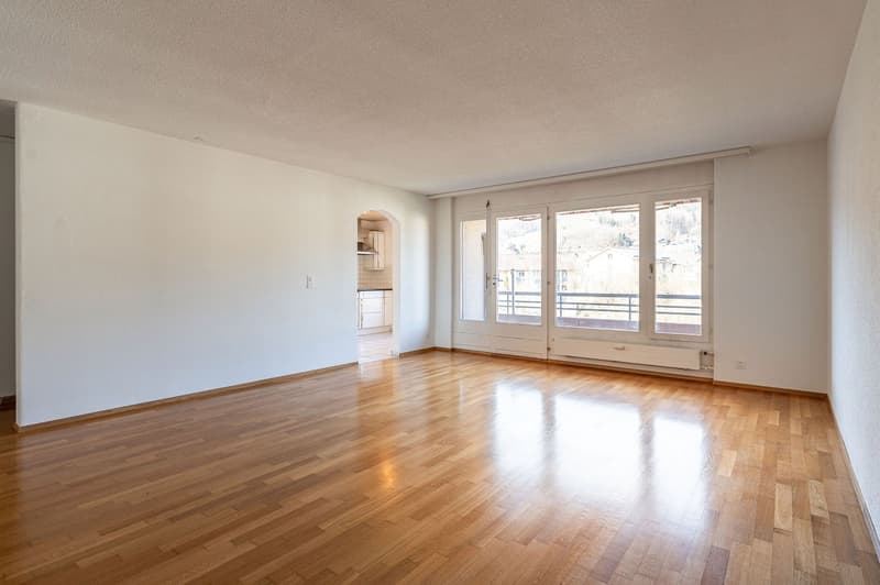 empty room, wooden floor, white walls, sliding glass doors leading to balcony
