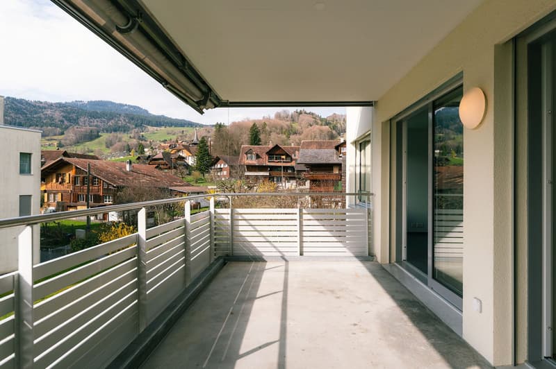 Balcony with metal railings, glass doors, wall lamp, view of the village and mountains