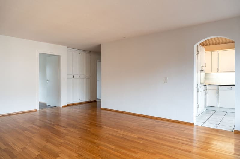 empty room, wooden floor, white walls, white cabinets, dishwasher