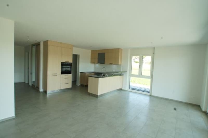 open-plan kitchen with modern appliances and cabinets, large window