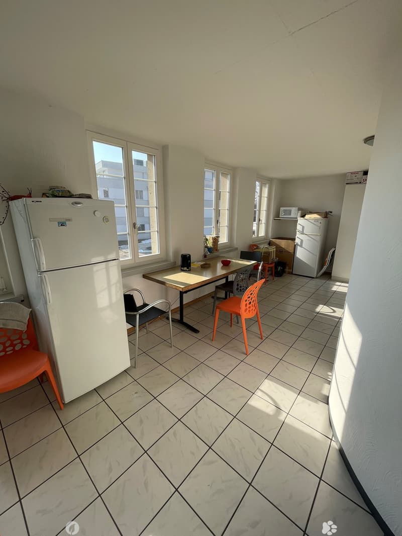 empty room, white walls, tiled floor, 2 fridges, dining table with 4 chairs, microwave on shelf, various objects on floor