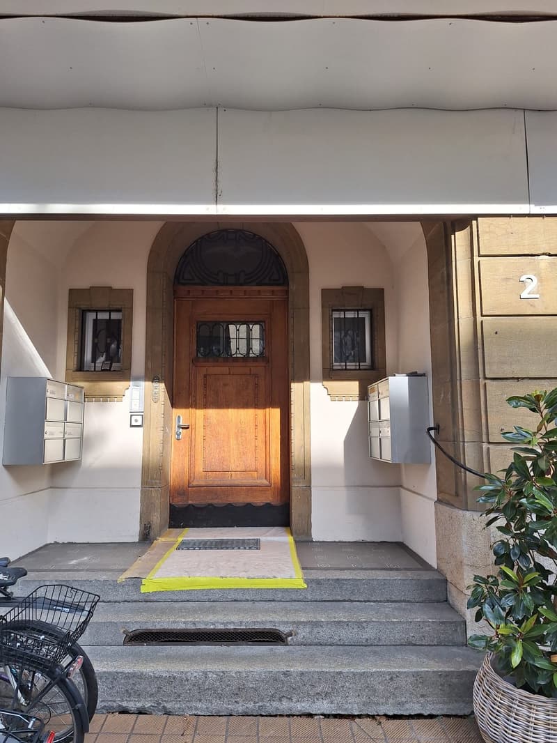 wooden door, arched entrance, mailboxes, steps, bicycles