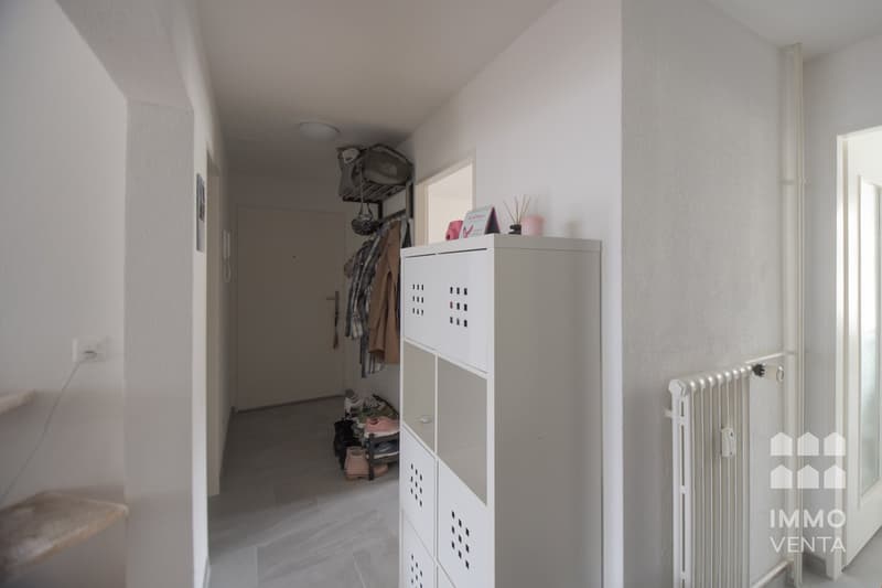 empty hallway, white walls, white flooring, white storage unit, closet, radiator