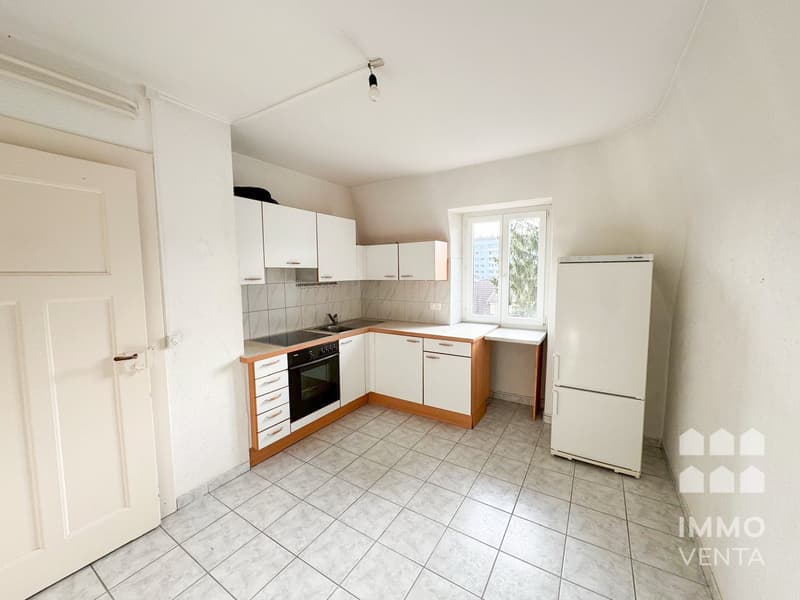 modern kitchen with white cabinets, tiled floor, black stove, white refrigerator, sink, window