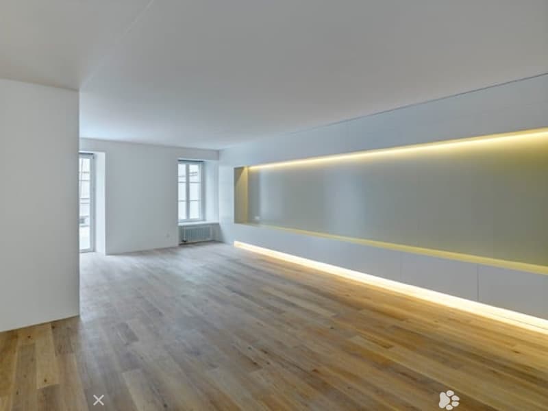 empty room, wooden floor, white walls, yellow lighting on wall, windows