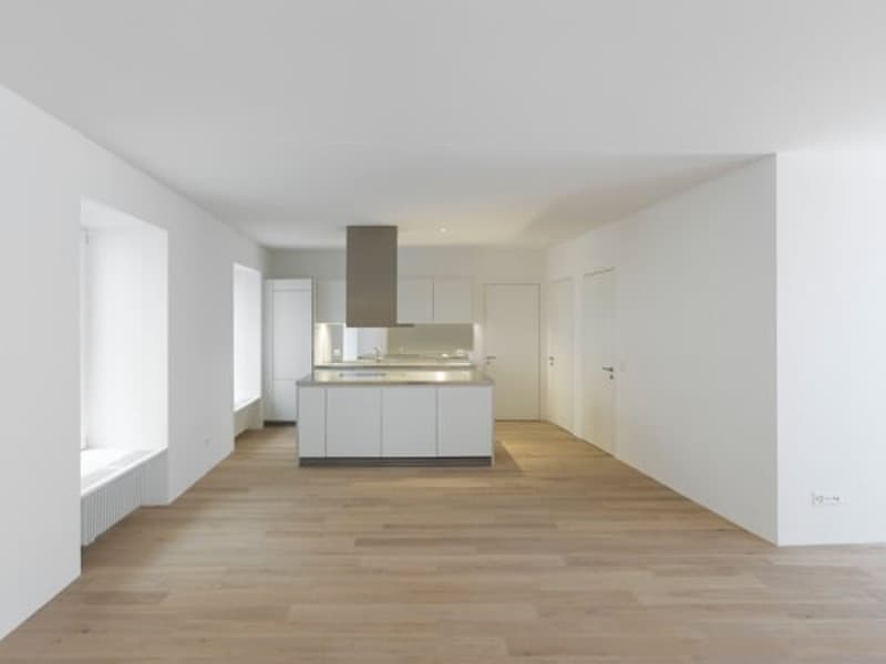 Open kitchen, white cabinets, wooden floor, white walls, central island, modern design