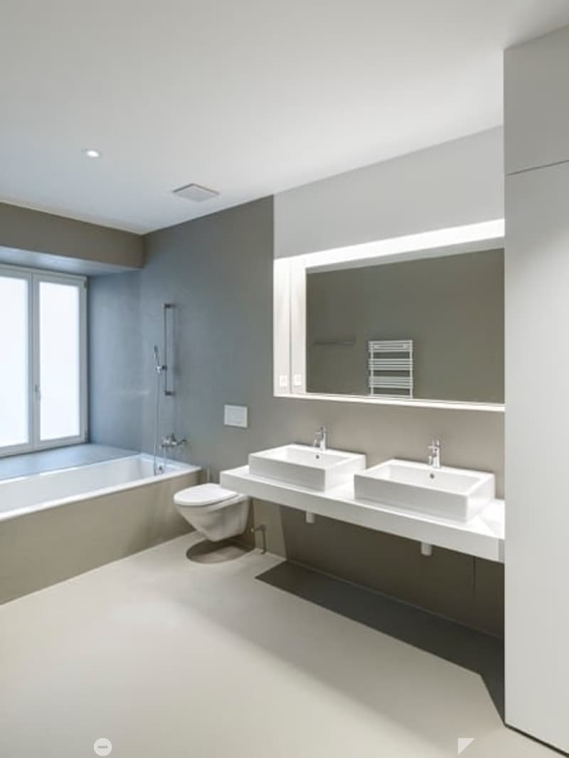 modern bathroom with bathtub, two sinks, toilet, large mirror, white walls, and ceiling