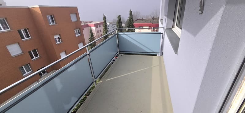 Balcony with railing, open view to the outside, tiled floor