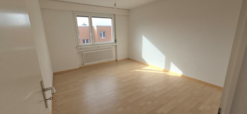 empty room with wooden floor, white walls, white radiator