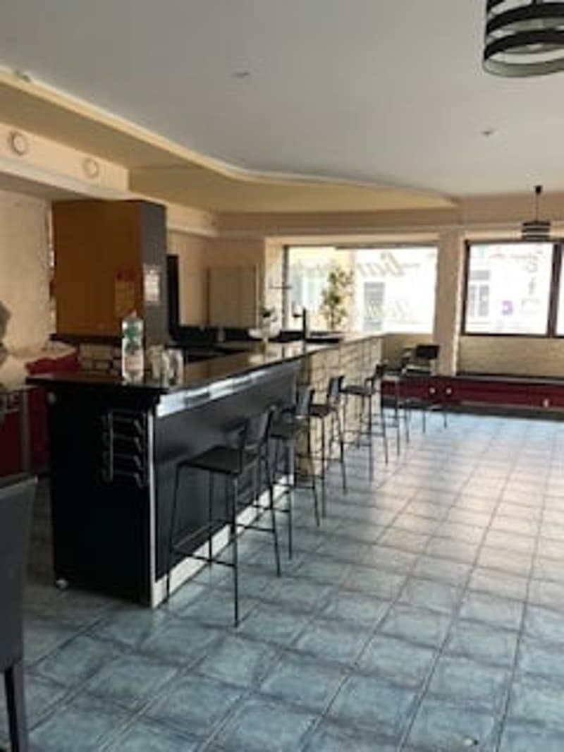 empty room, black bar counter, black chairs, tiled floor, large windows