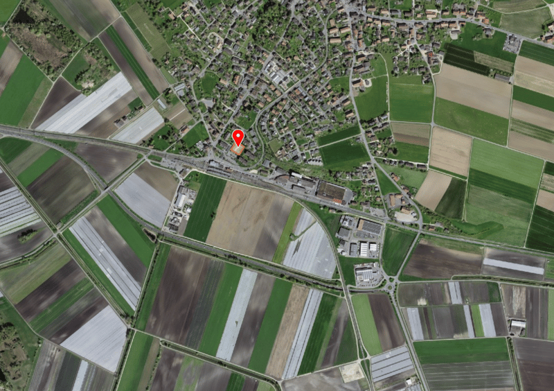 Green and brown fields with roads and a town in the center